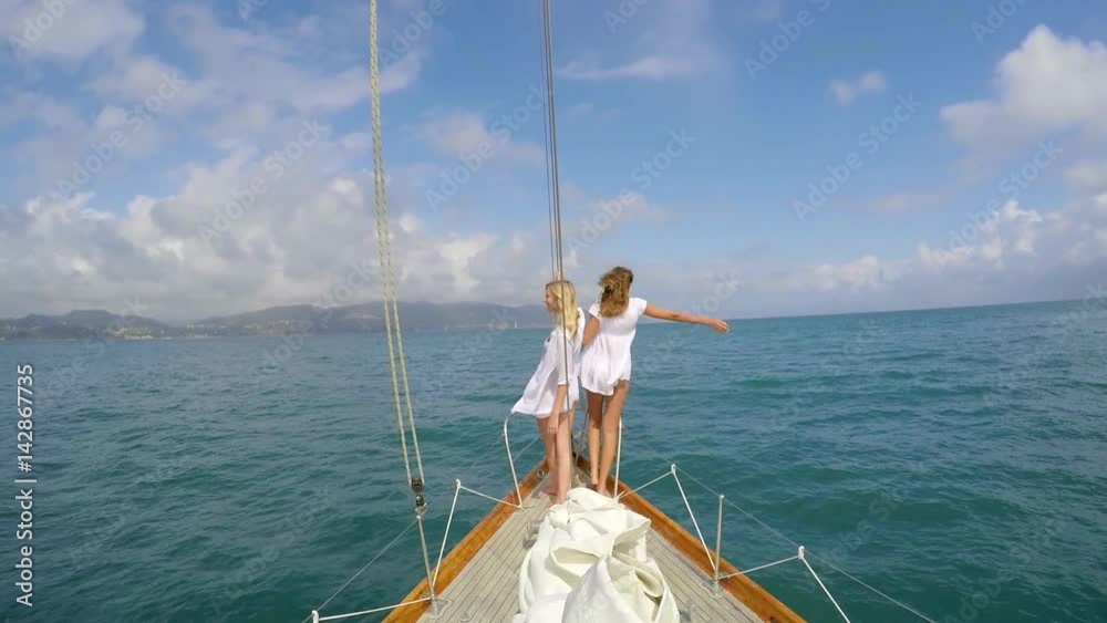 Beautiful girl friends enjoying view arms raised on sailboat in ocean on luxury lifestyle happy adventure travel vacation Beautiful girl friends enjoying view arms raised on sailboat in ocean on luxury lifestyle happy adventure travel vacation