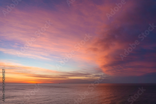 Beautiful sunrise, sunset sky over calm ocean © Olga K