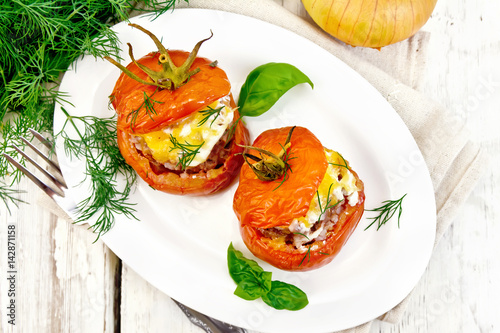 Tomatoes stuffed with meat and rice in plate on board top