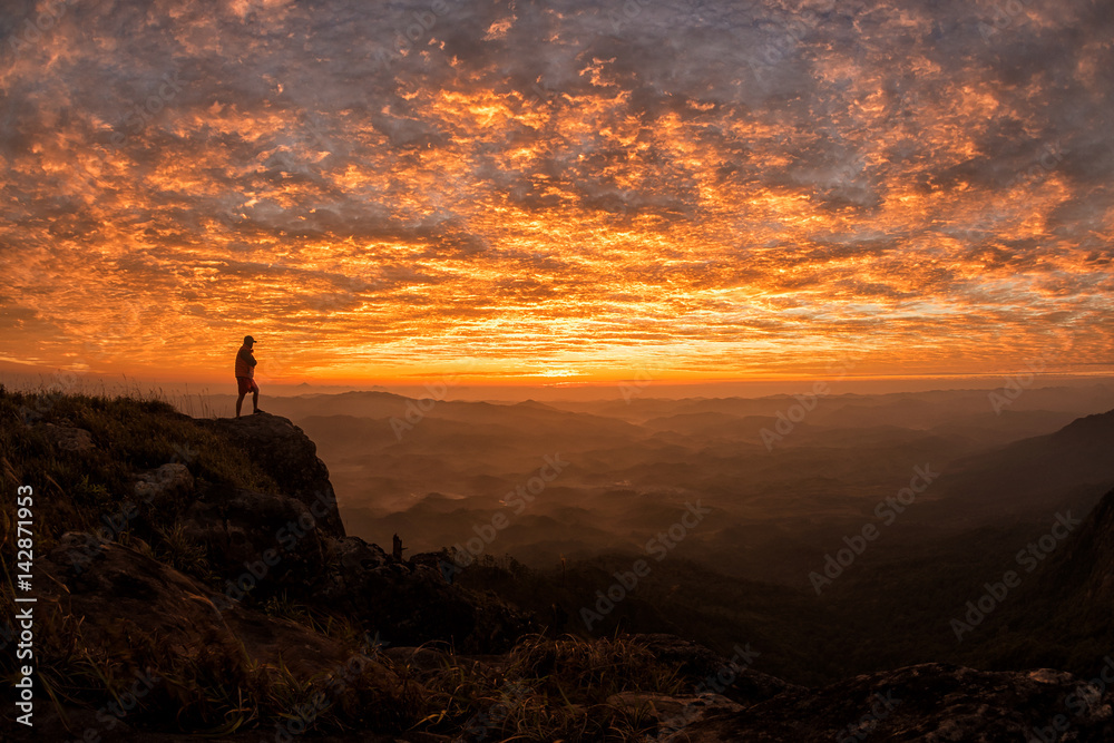 Obraz premium hiker celebrating success on top of a mountain in a majestic sunset