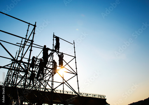 Construction workers working on scaffolding photo