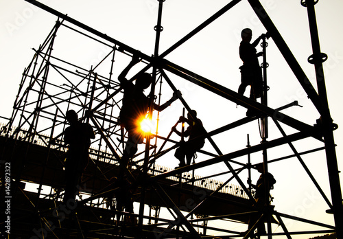 Construction workers working on scaffolding photo