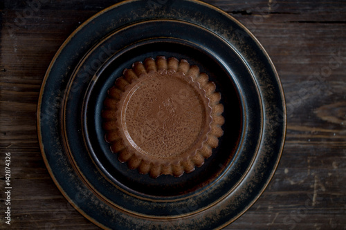 Panna cotta with chocolate on black old background