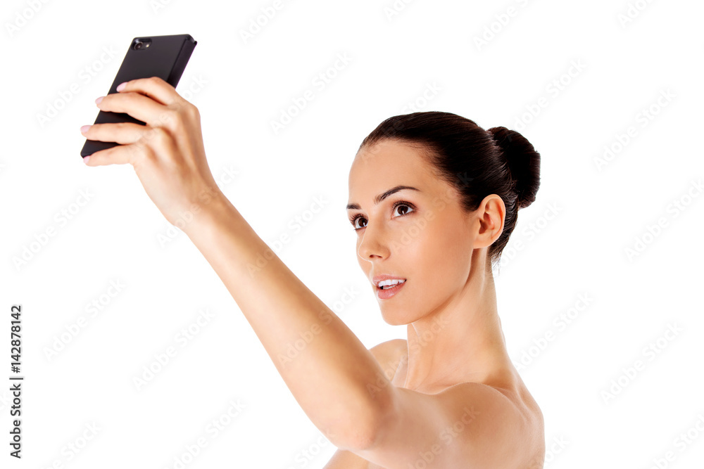Nude beautiful woman taking selfie on white background. Nude beautiful woman taking selfie on white background.