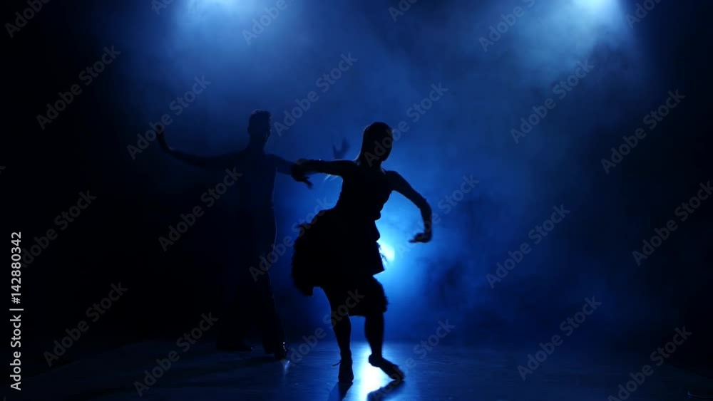 Silhouette of pair dancers performing modern dance in smoky studio Silhouette of pair dancers performing modern dance in smoky studio