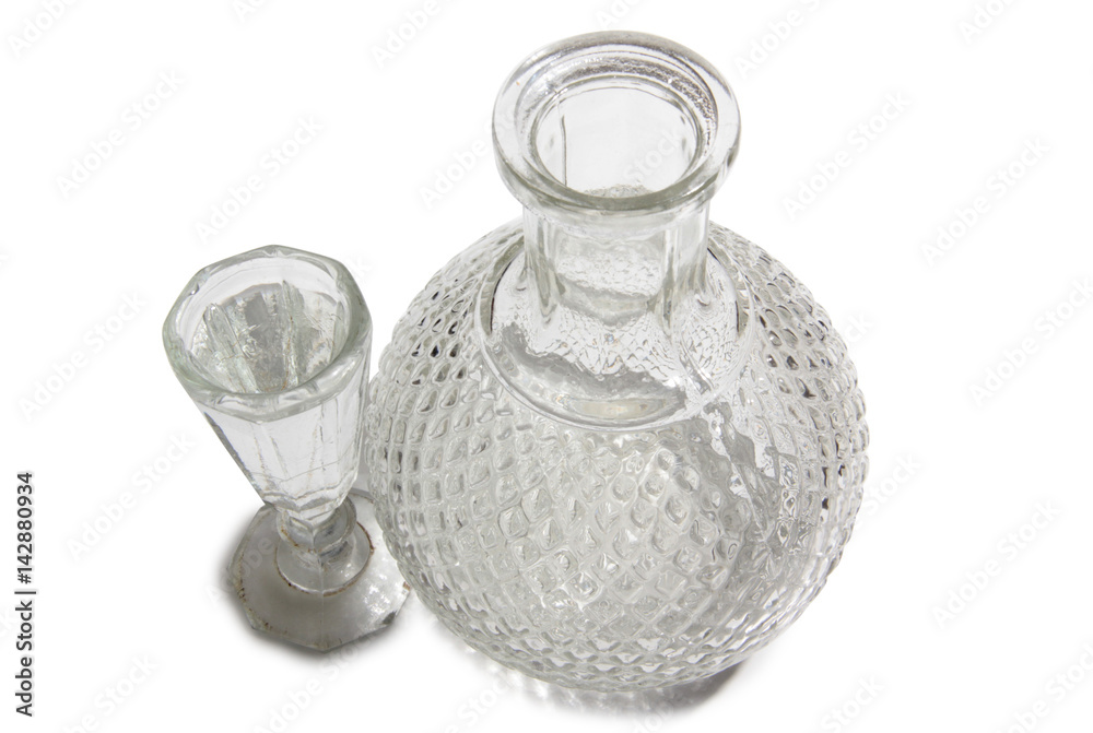 Vodka in a glass and decanter on a white background Vodka in a glass and decanter on a white background