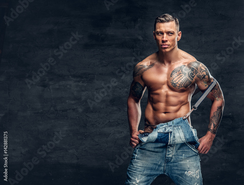 A man with a tattoo on his chest dressed in a jeans. © Fxquadro