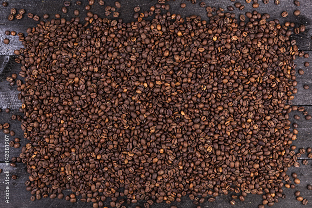 Fototapeta premium Frame of coffee beans on dark wooden background. Top view with copy space
