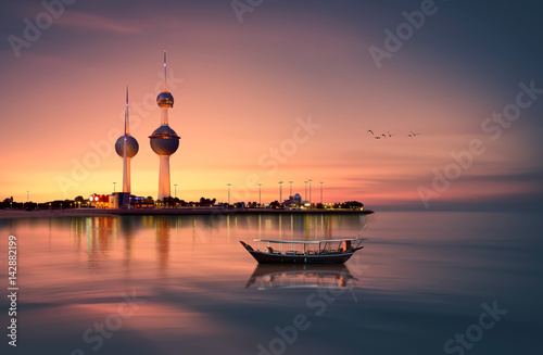 beautiful arabian boat in in front of kuwait tower during sunset