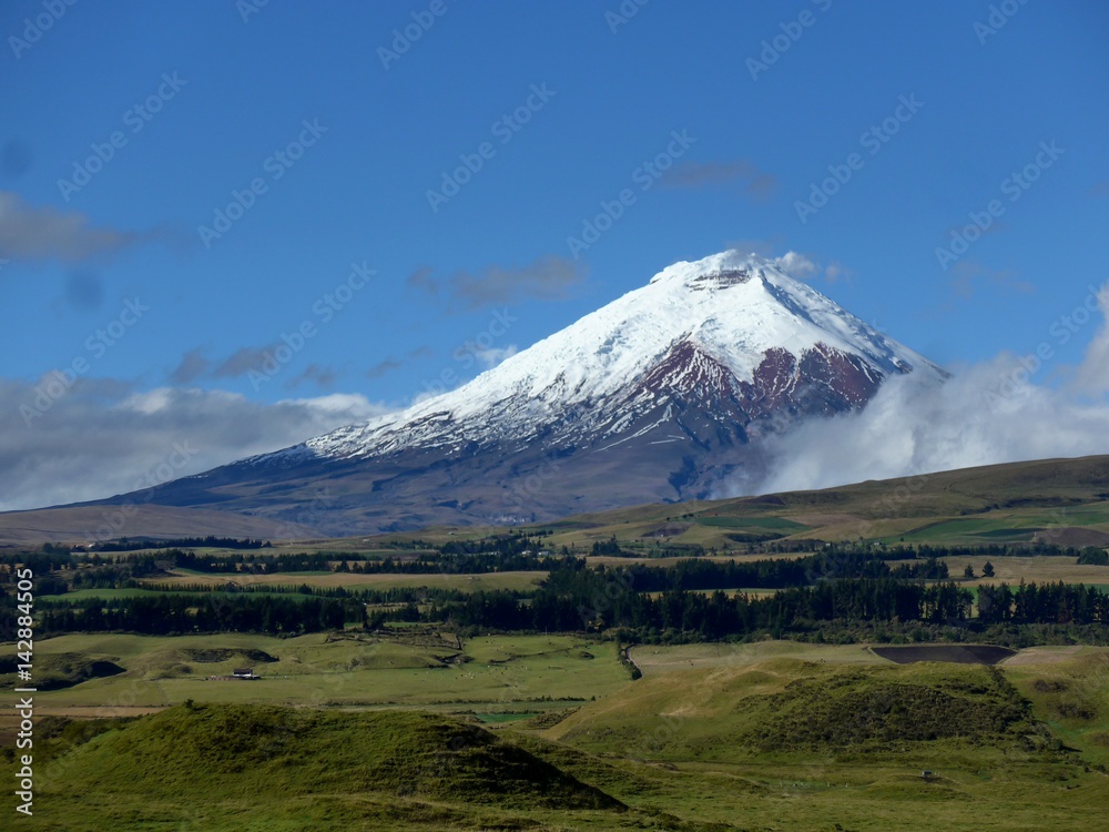 Farmland surrounding the active Cotopaxi Volcano on a stunning blue sky day. 