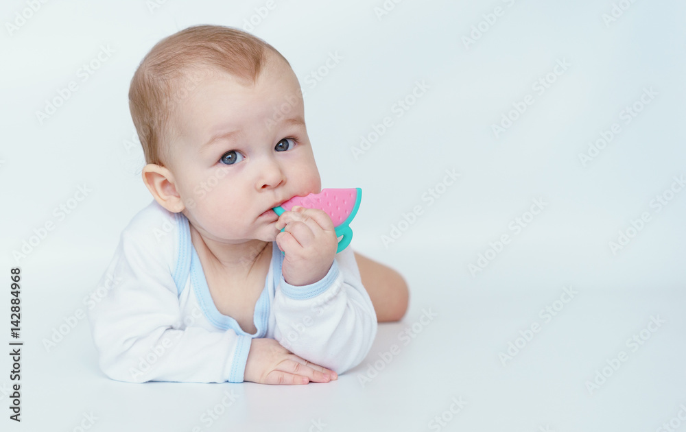 Portrait of adorable baby. Kid boy lying on his belly and holding teether toy. Portrait of adorable baby. Kid boy lying on his belly and holding teether toy.