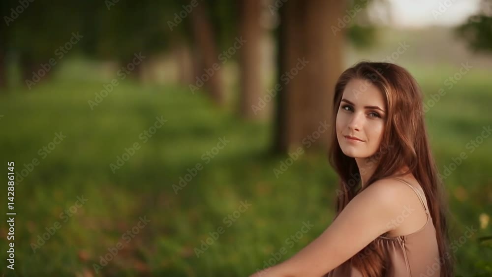 Beautiful young girl sitting near a tree, singing a song. Close-up. Beautiful young girl sitting near a tree, singing a song. Close-up.