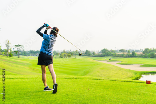 Lonely girl golfing on green golf course