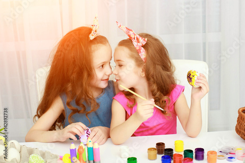 Two girls painting Easter eggs photo