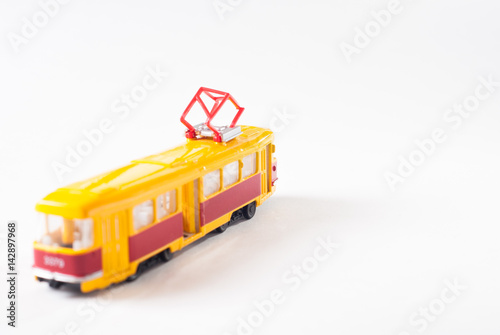 Toy tram in yellow on white background,