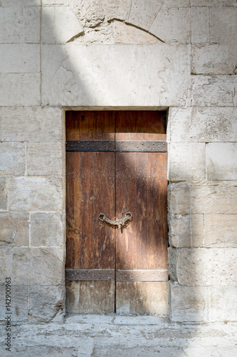 Wooden aged door and stone wall at Bebars Mosque, Medieval Cairo, Egypt photo