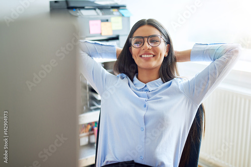 Cute young business owner leaning back in chair