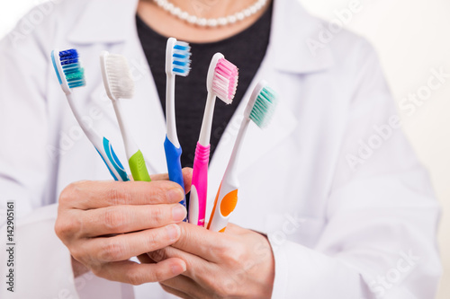 Dentist holding toothbrushes with different head and bristle design