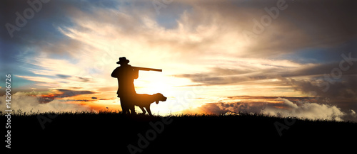 hunter with dog at sunset