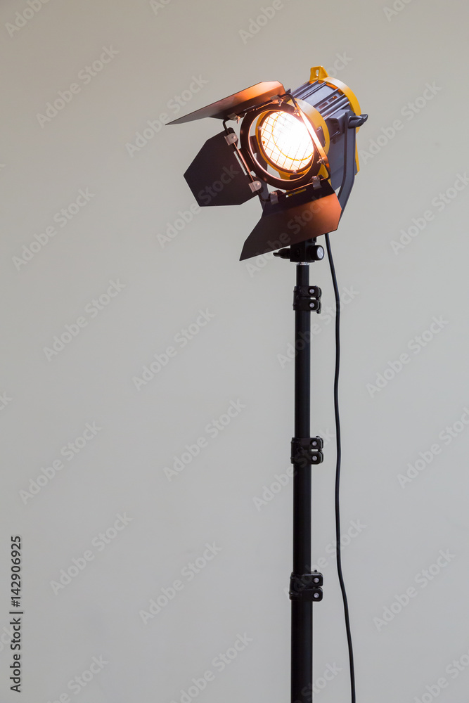 Spotlight with halogen bulb and Fresnel lens. Lighting equipment for Studio photography or videography. - obrazy, fototapety, plakaty 
