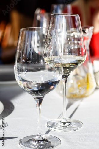 A glass of white wine stands on the table in the restaurant.
