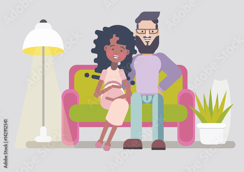 Happy interracial couple waiting for baby. Sitting on sofa. Cozy living room interrior.
