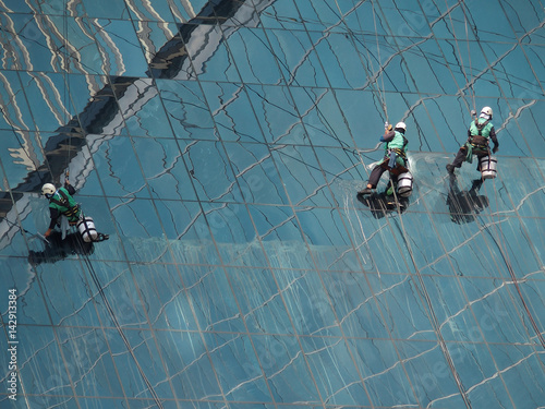 Men cleaning glass building