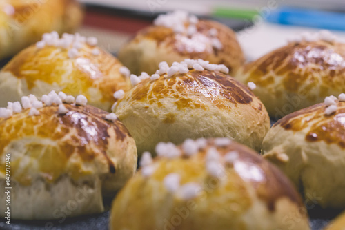 Freshly baked hot artisan bread buns beautifully golden straight out of the oven, cooling down