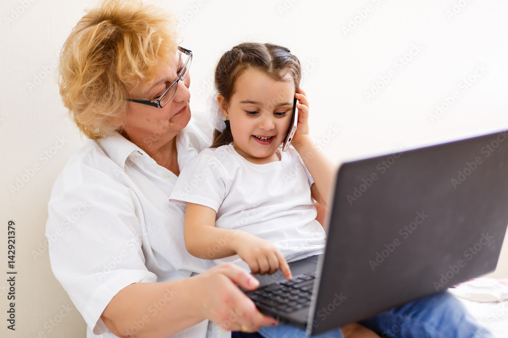 Asian grandmother and granddaughter looking at laptop Asian grandmother and granddaughter looking at laptop