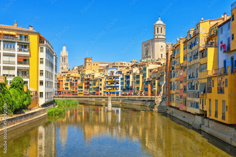 Colorful yellow and orange houses in historical jewish quarter of Girona, Catalonia, Spain. Saint Mary Cathedral.