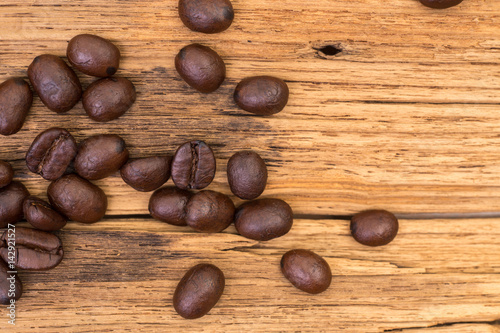 Roasted coffee beans on wood texture background. vintage color effected