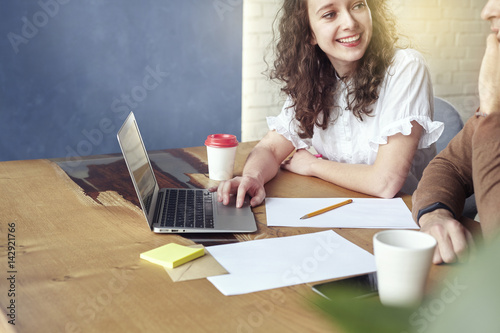 Two young professionals or students woman man happy with business meeting, smiling and talking about project. Office blue wall background