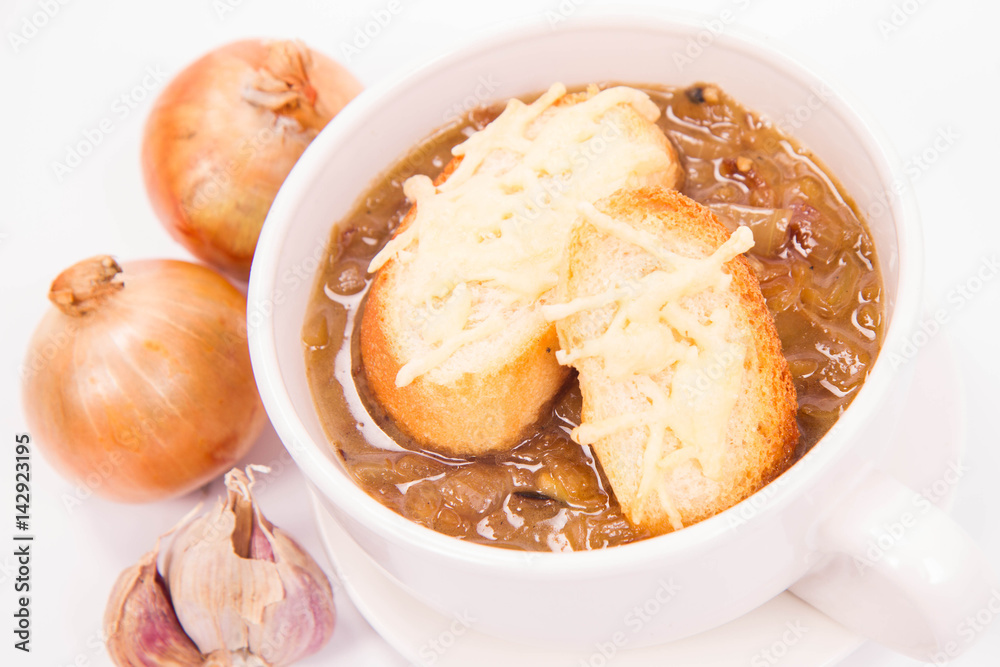 Onion soup with toast on a white background with some onions and garlic Onion soup with toast on a white background with some onions and garlic