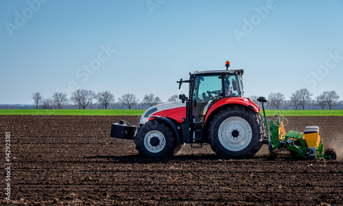 Agriculture tractor sowing seeds and cultivating field