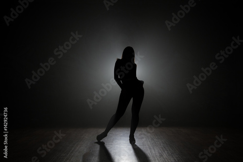 Dancer posing backlit. © semenenkostas