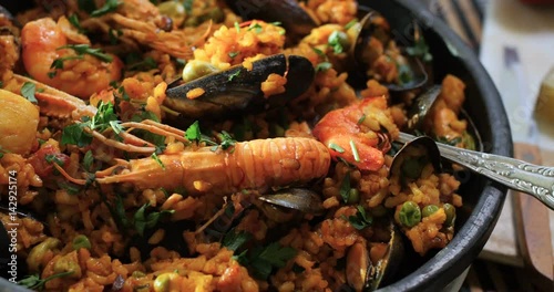 Dolly close up panning view of a Spanish seafood paella: mussels, king prawns, langoustine, haddock photo