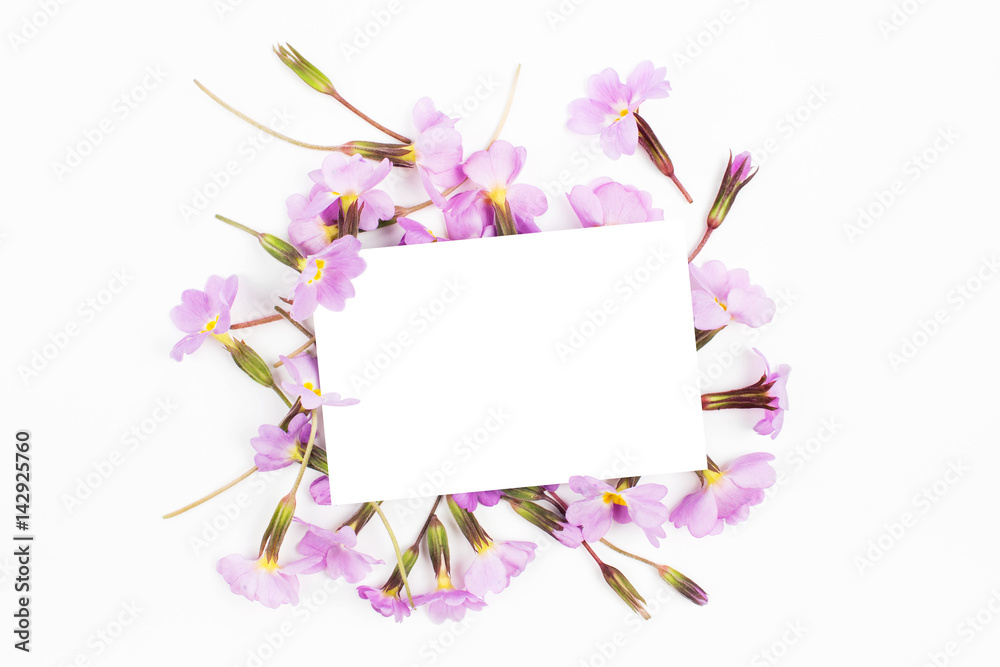 Empty card  and floral composition with  lilac and purple  flowers on white background. Flat lay, top view. Flowers  mockup