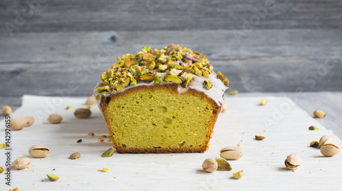 Avocado-Kuchen mit Zitronenguss und Pistazientopping im Anschnitt frontalaufnahme