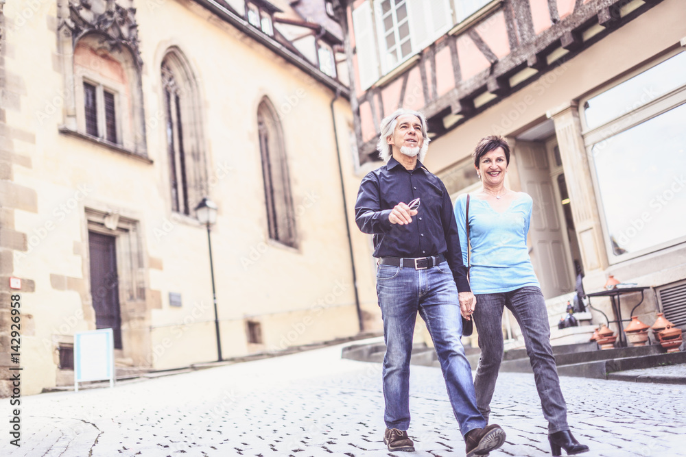 Senior Couple Walking Through The Streets Of T�bingen, Germany Senior Couple Walking Through The Streets Of T�bingen, Germany