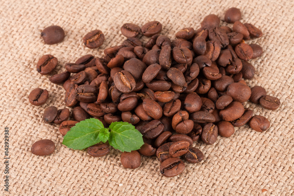 Fototapeta premium heap of coffee beans on sackcloth close-up