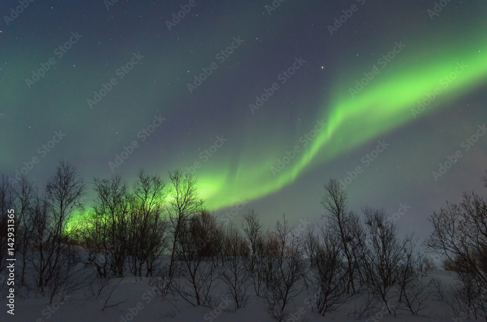 The hills are covered with snow and the Aurora .Night.