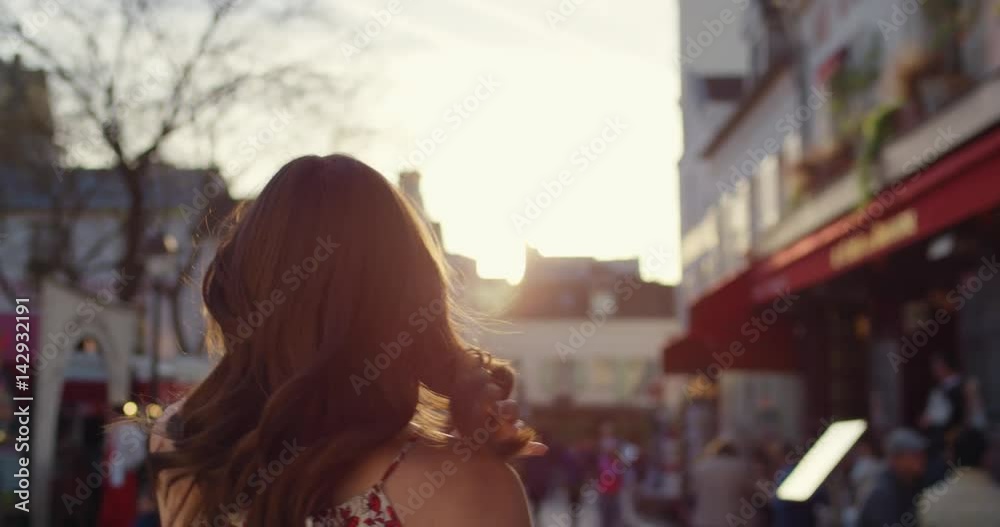 Rear view woman walking through European street at sunset wearing pretty floral summer dress sunshine lens flare confident girl exploring local Paris enjoying holiday travel vacation adventure Rear view woman walking through European street at sunset wearing pretty floral summer dress sunshine lens flare confident girl exploring local Paris enjoying holiday travel vacation adventure