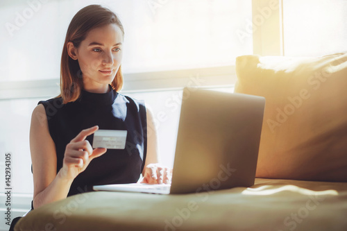 Businesswoman working from home and using gold credit card for online orders, Happy woman using laptop and credit card for online shopping at home