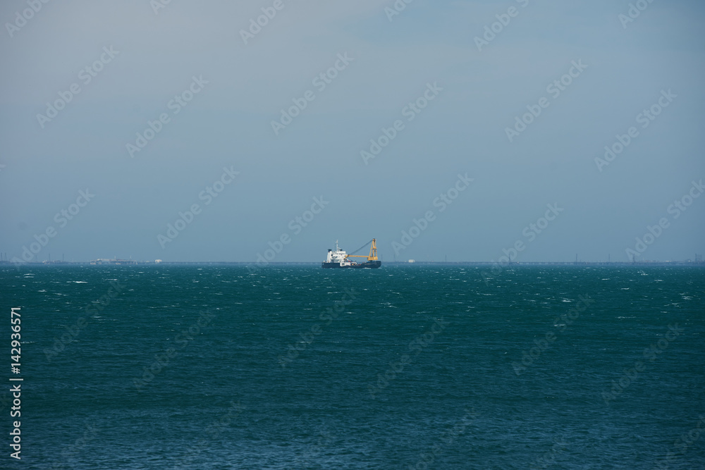 A fishing boat trawler floating in the open waters of the blue Caspian Sea.Concept of spring fishing. A fishing boat trawler floating in the open waters of the blue Caspian Sea.Concept of spring fishing.