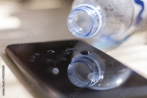 Water spilled from a bottle onto a smartphone