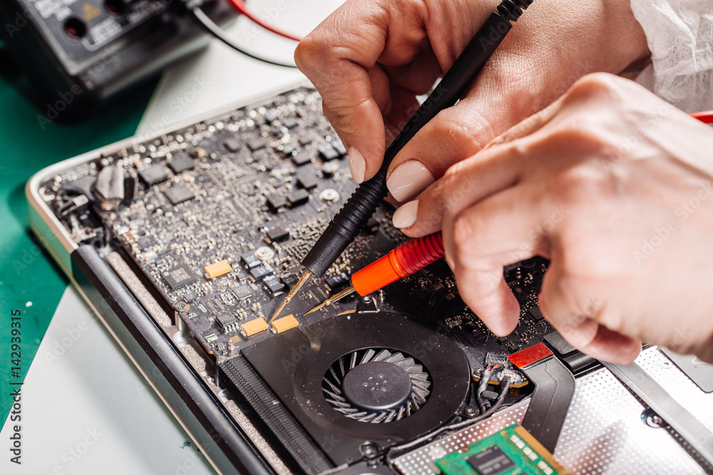 Naklejka premium woman repairing laptop computer in service center. Repairing and fixing service in lab. Electronics repair service concept.