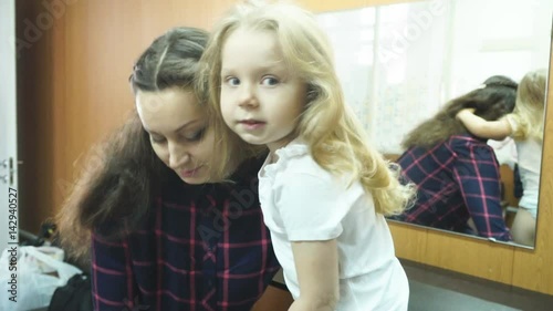 Mother daughter dresses yellow tulle skirt, preparing for a photo shoot