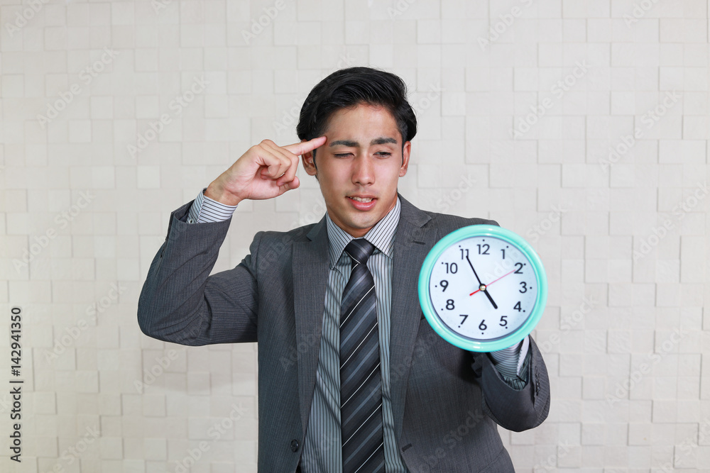時計を持つ疲れた表情のビジネスマン 時計を持つ疲れた表情のビジネスマン