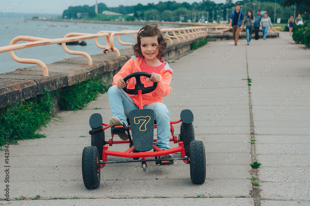 Little girl is riding on pedal karting. Little girl is riding on pedal karting.