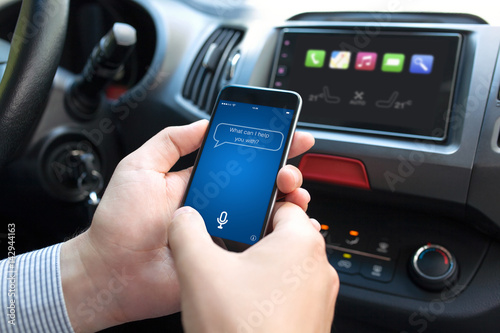 man hand in car holding phone with app personal assistant